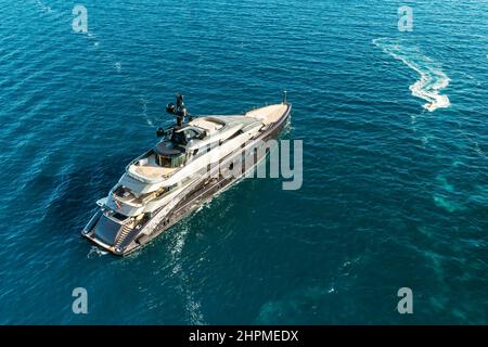 ROVINJ, TSCHECHISCHE REPUBLIK - JULI 03 2021: Luxuriöse Yacht driftet im Adriatischen Meer, beleuchtet von hellem Sonnenlicht, das vom Wasser reflektiert wird. Ruhiges, plätscherndes Wasser mit kleinen Wellen. Obere Ansicht Stockfoto