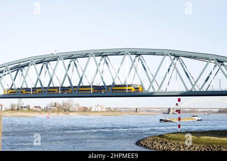 Zug auf Eisenbahnbrücke über den Fluss Waal in Nijmegen in den Niederlanden Stockfoto