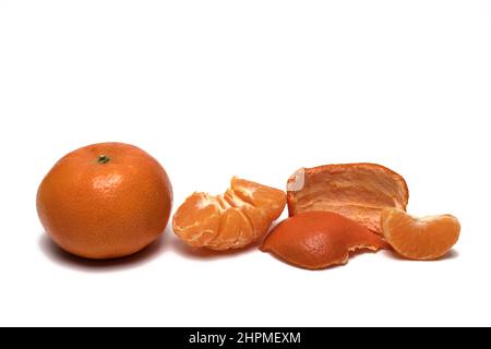 Nahaufnahme der reifen Mandarine neben den Schalen und geschälte Hälfte mit Scheibe auf weißem Hintergrund Stockfoto