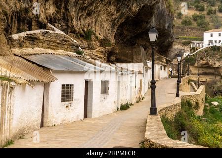 Setenil de las Bodegas, Spanien - 19. Februar 2022: Historische, weiß getünchte Entwässerungen unter Felsüberhängen entlang des Rio Trejo Stockfoto