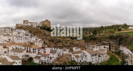 Setenil de las Bodegas, Spanien - 19. Februar 2022: Panoramablick auf die Wahrzeichen-Stadt Setenil de las Bodegas in Andalusien Stockfoto