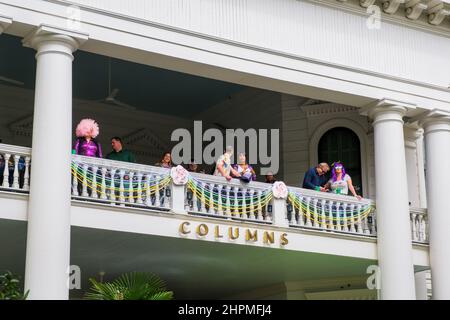 NEW ORLEANS, LA, USA - 20. FEBRUAR 2022: Menschen beobachten die Femme Fatale Parade vom Balkon des historischen Columns Hotel auf der St. Charles Avenue Stockfoto