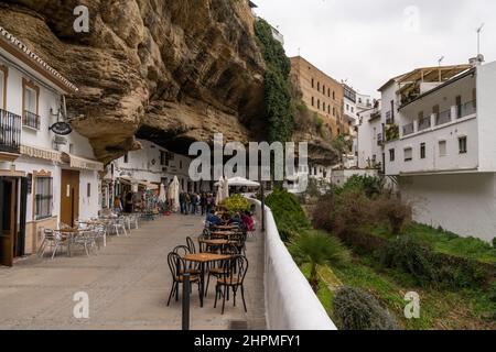 Setenil de las Bodegas, Spanien - 19. Februar 2022: Die Menschen genießen einen Tag in der Altstadt von Setenil de las Bodegas Stockfoto