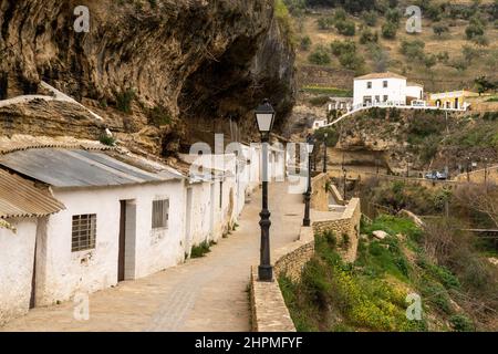 Setenil de las Bodegas, Spanien - 19. Februar 2022: Historische, weiß getünchte Entwässerungen unter Felsüberhängen entlang des Rio Trejo Stockfoto