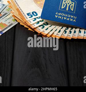 Ukraine Pässe und Geld Dollar, Euro. Fremdes biometrisches Dokument, das die Identität eines Bürgers der Ukraine belegt. Stockfoto