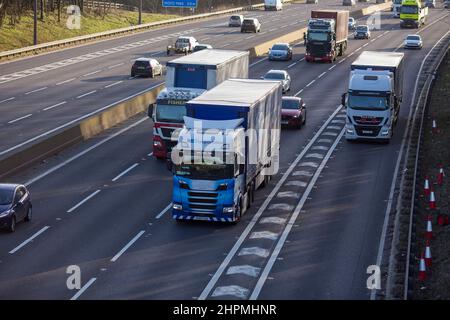 Lastwagen, Autos und Lieferwagen fahren an einem Februarnachmittag auf der M62 zwischen den Anschlussstellen 25 und 26. Die M62 ist eine 107 Meilen (172 km) lange West-Ost-Trans-Pennine-Autobahn in Nordengland, die Liverpool und Hull über Manchester, Bradford, Leeds und Wakefield in Großbritannien verbindet. Kredit: Windmill Images/Alamy Live Nachrichten Stockfoto