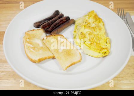 Ein Käse-Omelett mit einer Seite von weißem Toast und Würstchen Stockfoto