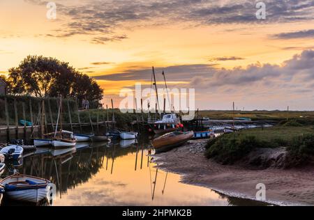 Dämmerung auf der Flussmündung des Glaven bei Ebbe mit Booten und Wolkenspiegelungen, Blakeney, ein kleines Küstendorf an der Nordküste Norfolk, England Stockfoto