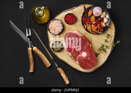 Blick von oben auf rohes, frisches Lammfleisch mit mittelgeschnittenem Bein und Gewürzen Stockfoto