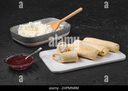 Hausgemachte Pfannkuchen, gefüllt mit Quark auf einem Servierteller aus Marmor Stockfoto