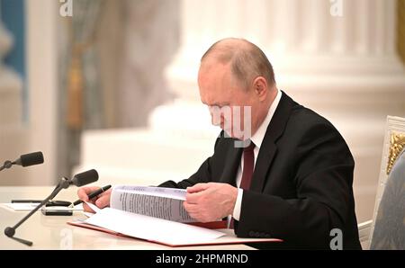 Moskau, Russland. 21st. Februar 2022. Der russische Präsident Wladimir Putin unterzeichnet während einer Zeremonie im Kreml am 21. Februar 2022 in Moskau, Russland, einen Exekutivbefehl zur Anerkennung der separatistischen Regionen Donezk und Lugansk. Das Abkommen setzt die Angliederungsdmachung ukrainischen Territoriums in die Russische Föderation fort. Quelle: Alexei Nikolsky/Kremlin Pool/Alamy Live News Stockfoto