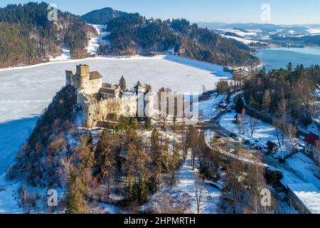 Polen. Mittelalterliche Burg in Niedzica, aus dem 14th. Jahrhundert (obere Burg) im Winter. Gefrorener künstlicher Czorsztyn-See auf dem Dunajec-Fluss und ein Damm Stockfoto