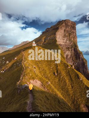 Kallur Leuchtturm auf den grünen Hügeln der Kalsoy Insel, Färöer Inseln, Dänemark. Landschaftsfotografie. Farben für Retro-Filmscans Stockfoto