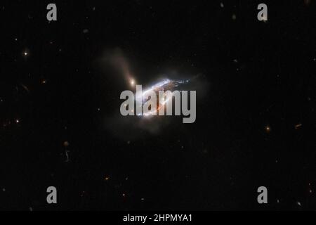 Das NASA/ESA-Weltraumteleskop Hubble hat eine scheinbar im Gange befindlichen Dreifach-Galaxienfusion eingefangen, sowie eine turbulente Mischung aus Sternentstehung und Gezeitenverzerrungen, die durch die Gravitationswechselwirkungen dieses galaktischen Trios verursacht werden. Eine dicke Staubwolke verdeckt das Zentrum dieses Bildes - obwohl das Licht einer Hintergrundgalaxie in ihre äußeren Extremitäten dringt. Die Staubmasse und die hellen Sternwirbel in diesem Bild sind die ferne Galaxie Merger IC 2431, die 681 Millionen Lichtjahre von der Erde im Sternbild Krebs entfernt liegt. NASA/ESA/UPI Stockfoto