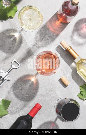 Rot-, Weiß- und Roséwein in Weingläsern auf betontem Hintergrund. Draufsicht. Getränke- und Weinkonzept. Stockfoto