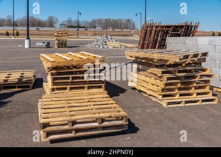 Horizontale Aufnahme von Holzpalettenstapeln und anderen Vorräten auf einer Industriebaustelle. Stockfoto