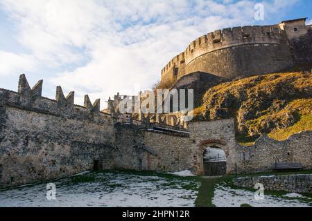 Besenello, Italien - Dez 26 2021. Das mittelalterliche Schloss Beseno aus dem 12th. Jahrhundert im Lagarina-Tal, Trentino, Norditalien. Das Turnierfeld steht im Vordergrund Stockfoto