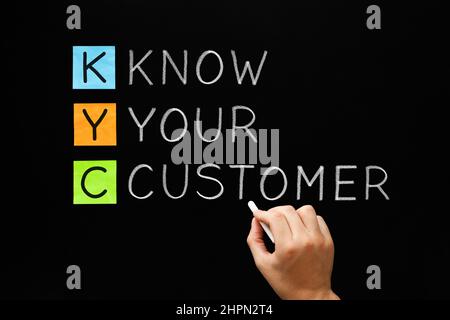Businessman Writing KYC - Know Your Customer Akronym mit Kreide auf der Tafel. Konzept über den Prozess der Identifikation und Verifizierung der ide Stockfoto