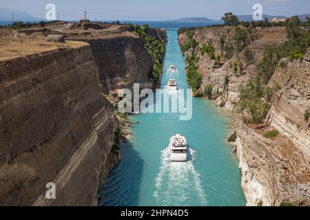 Die schöne Landschaft der Kanal von Korinth in einem hellen, sonnigen Tag gegen ein blauer Himmel mit weißen Wolken. Zwischen den Felsen fließenden weißen Schiff in Türkis wa Stockfoto