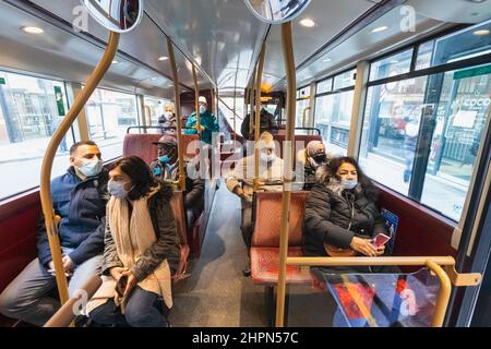 England, London, Gruppe sitzender Busfahrer mit chirurgischen Masken Stockfoto