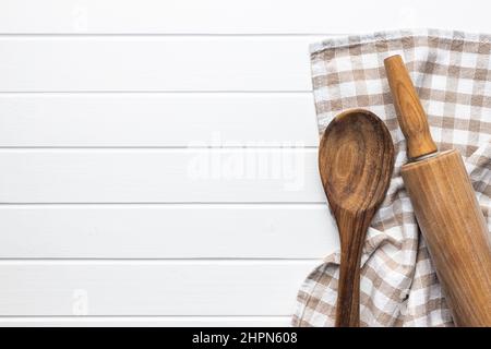 Nudelholz und Holzlöffel auf einem Holztisch mit karierter Tischdecke. Draufsicht mit Kopierbereich. Stockfoto