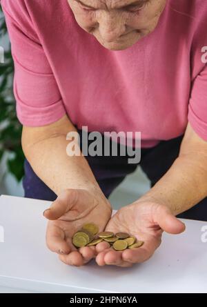 Eine alte Frau zählt kleines Geld. Selektiver Fokus. Stockfoto