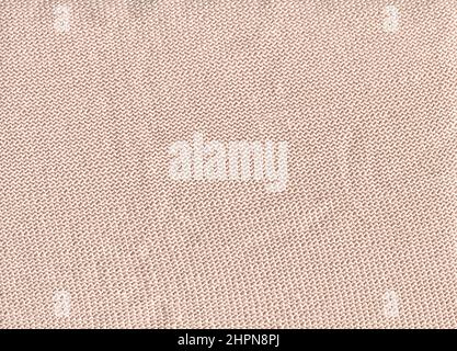 Handgemachte Strickgewebe Leinwandstruktur in beige Creme Farbe. Kuschelige cremefarbene Textildecke aus nächster Nähe. Stockfoto