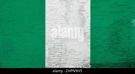 Vollformatfoto einer verwitterten Flagge von Nigeria, gemalt auf einer verputzten Ziegelwand. Stockfoto