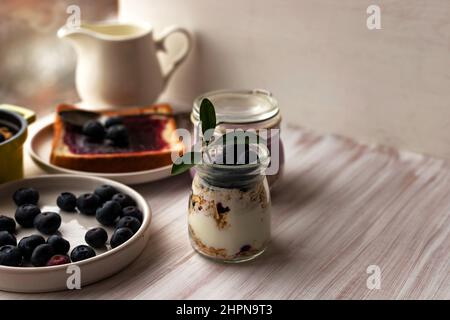 Haferflocken Müsli Parfait, über Nacht Haferflocken im Glas, geröstetes Brot, Heidelbeermarmelade Stockfoto