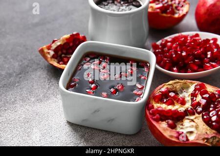 Schale mit Granatapfelmelasse und frischem Obst auf dem Tisch Stockfoto