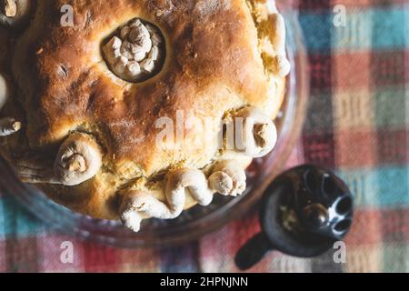 Der Familienvater hält die Feier des schutzpatrons Ein hausgemachtes Slava-Kuchenbrot von oben auf dem Tisch, um traditionelle Gerichte zu feiern, die für einen orthodoxen Urlaub zubereitet werden Stockfoto