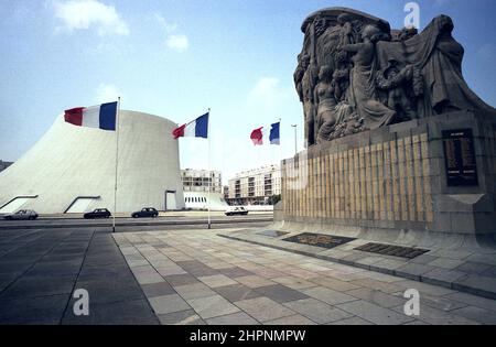 AJAXNETPHOTO. LE HAVRE, FRANKREICH. - DENKMÄLER - (L-R) DAS OSCAR NIEMEYER KULTURZENTRUM 'LE VOLCAN' ODER VULKAN IM JAHR 1982 GEBAUT UND DIE STADT 'S WAR MEMORIAL IN PLACE GENERAL DE GAULLE VON BILDHAUER PIERRE-MARIE POISSON AUS GRANIT IM JAHR 1928 GEMACHT. FOTO: JONATHAN EASTLAND/AJAX REF:EPS210204 11 Stockfoto