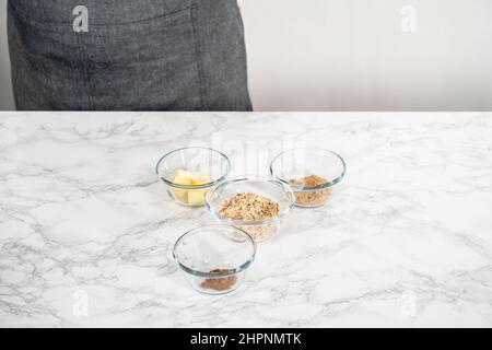 Gemessene Zutaten in Glasschüsseln zum Backen von Bananen-Haferflocken-Muffins. Stockfoto