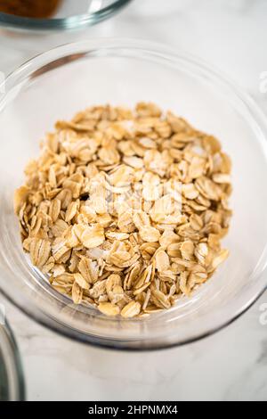 Gemessene Zutaten in Glasschüsseln zum Backen von Bananen-Haferflocken-Muffins. Stockfoto