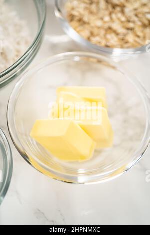 Gemessene Zutaten in Glasschüsseln zum Backen von Bananen-Haferflocken-Muffins. Stockfoto