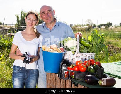 Glückliches Paar mit Ernte von Gemüse im Garten Stockfoto