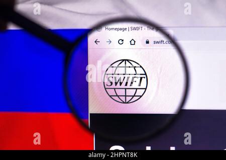 In dieser Abbildung ist das Logo der Society for Worldwide Interbank Financial Telecommunication (SWIFT) zu sehen, das durch eine Lupe auf einem Computerbildschirm angezeigt wird. Stockfoto