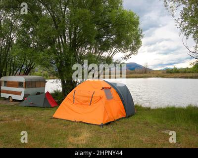 Freedom Camper Urlaub mit Zelt und Wohnwagen am Rande des Lake Poaka, Südinsel, Neuseeland Stockfoto