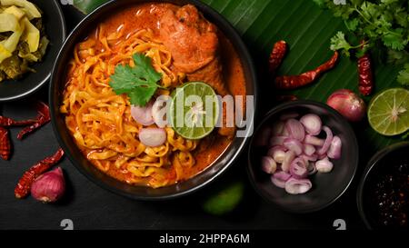 Khao Soi Kai mit frischem Gemüse Beilage auf Bananenblatt im Hintergrund. Thailändisches Rezepturkonzept Stockfoto