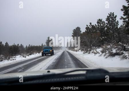 Reno, Usa. 22nd. Februar 2022. Autos fahren auf einer schneebedeckten Straße. Die winterlichen Straßenverhältnisse verschlechtern sich, da Schnee in den Bergen fällt. Bei allen Fahrzeugen außer dem 4-Rad-Antrieb mit Schneereifen Ketten, sofern erforderlich. Kredit: SOPA Images Limited/Alamy Live Nachrichten Stockfoto