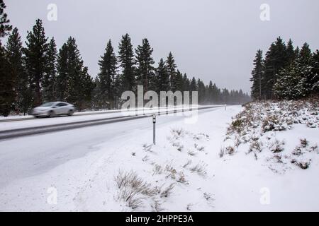 Reno, Usa. 22nd. Februar 2022. Ein Auto fährt auf einer schneebedeckten Straße. Die winterlichen Straßenverhältnisse verschlechtern sich, da Schnee in den Bergen fällt. Bei allen Fahrzeugen außer dem 4-Rad-Antrieb mit Schneereifen Ketten, sofern erforderlich. Kredit: SOPA Images Limited/Alamy Live Nachrichten Stockfoto