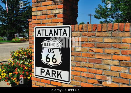 Atlanta, Illinois, USA. Stadt mit Identität zur Mother Road, US Route 66, ein Straßenschild auf einer Backsteinmauer ist eine Hommage an die berühmte Straße. Stockfoto