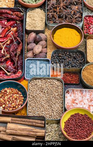 Aromatische Gewürze in Dosen und Schalen Stockfoto