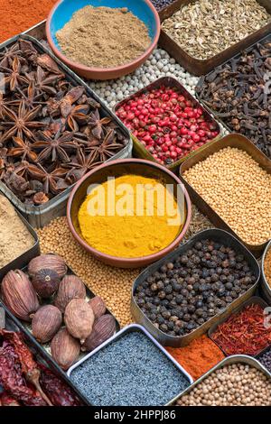 Aromatische Gewürze in Dosen und Schalen Stockfoto