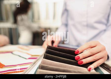 Frau wählt Stoff in Möbelhaus Nahaufnahme Stockfoto