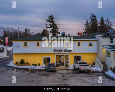 New Hartford - 16. Februar 2022: Nahaufnahme der Nacht Blick auf das Äußere des Branjen Realty Building. Branjen Realty ist ein florierendes lokales Geschäft. Stockfoto