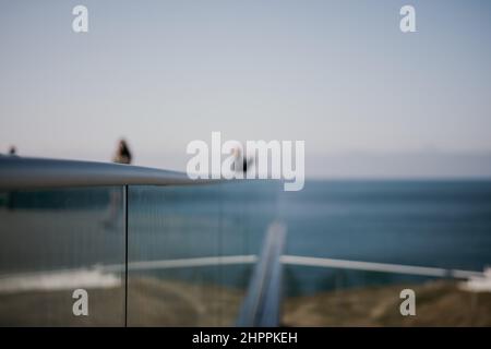 Abstrakter selektiver Glaszaun im Seepark. Ein beliebter Aussichtspunkt, der die natürliche Schönheit des Sonnenuntergangs bewundert. Eine Aussichtsplattform mit einem Stockfoto