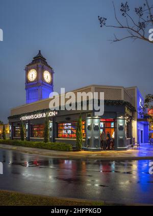 Kissimmee, Florida - 5. Februar 2022: Vertikale Vollgebäude-Nachtansicht von Yeoman's Cask & Lion mit Big Pen Mini Tower. Yeoman's ist ein britischer Pub und Stockfoto