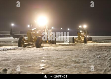 Senior Airman Austin Schafer, 19th Civil Engineer Squadron, links, und Senior Airman Jason Bridgman, 19th CES, rechts, räumen die Fluglinie von Schnee und Eis nach einem Wintersturm auf der Little Rock Air Force Base, Arkansas, 4. Februar 2022. Bauingenieure der CES 19th arbeiteten Tag und Nacht daran, LRAFB während des Wintersturms Landon in Betrieb zu halten. (USA Luftwaffe Foto von 1st LT. Daniel Hendrix) Stockfoto