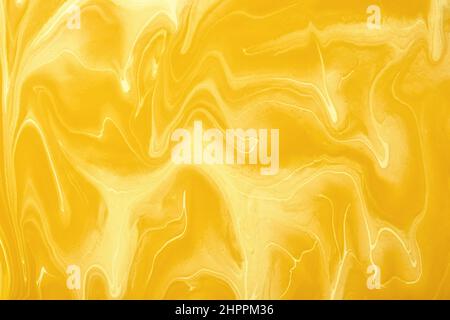 Abstrakte flüssige Kunst Hintergrund gelb und goldene Farben. Flüssiger Marmor. Acrylmalerei auf Leinwand mit ockerfarbener Farbverlauf und Spritzer. Hintergrund für alkoholhaltige Tinte Stockfoto